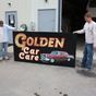 Photo of two men standing by Golden Care Care sign