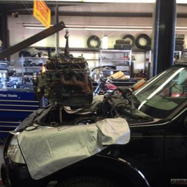 Black car being repaired inside garage