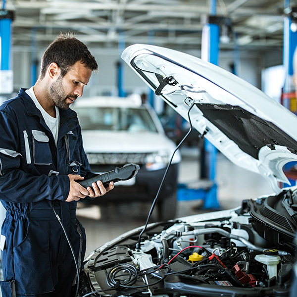 Auto mechanic working with car diagnostic tool in a repair shop