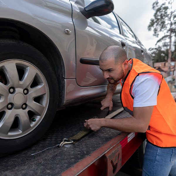 Tow truck operator towing a car