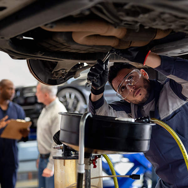 Mechanic working at an auto repair shop fixing a car