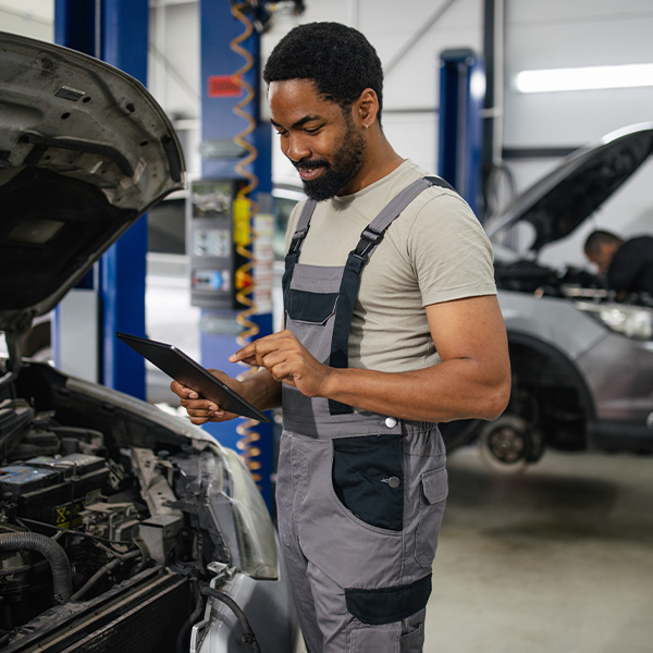 Automotive technician uses a tablet to diagnose a vehicle